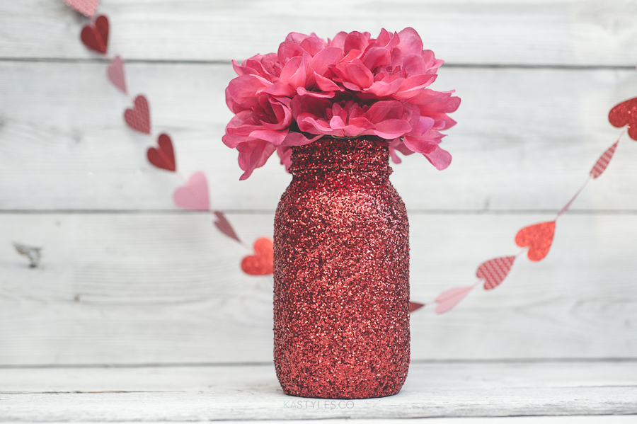 Red glitter Valentine's Day mason jar vase for decor or gifts.